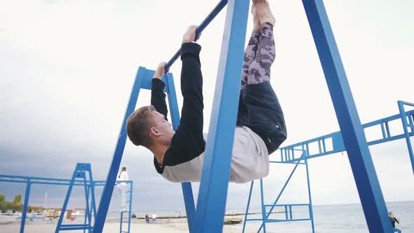 Young Man Doing Parkour Tricks on the Beach Near the Sea