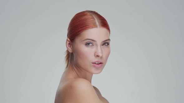 Studio portrait of young, beautiful and natural redhead woman. Beauty concept.