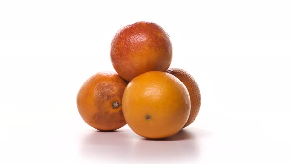 Four Red Oranges are Spinning on White Background