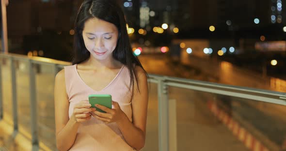 Woman use of smart phone in the street at night 