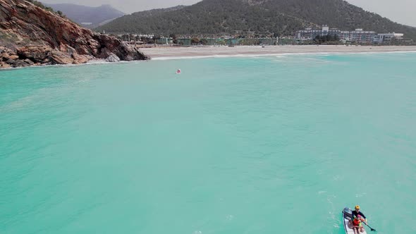 Family Paddleboarding Down the Sea