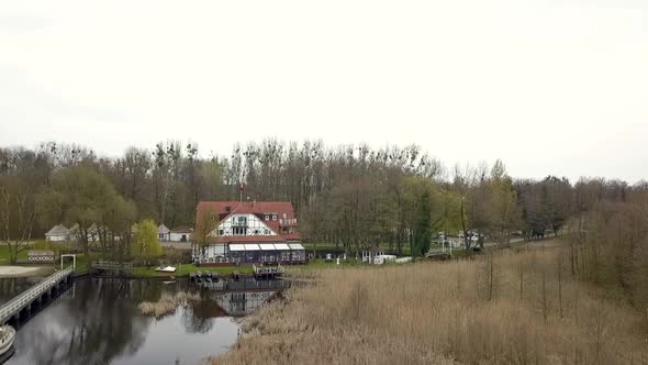 Dramatic aerial flight fly forwards drone shot A white half-timbered house atspring sunset on a lak