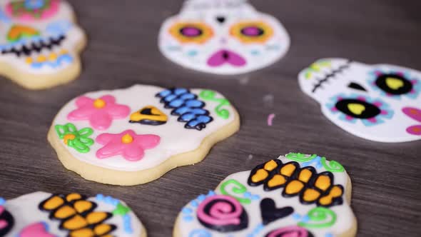 Time lapse. Step by step. Decorating sugar skull cookies with different color royal icing.