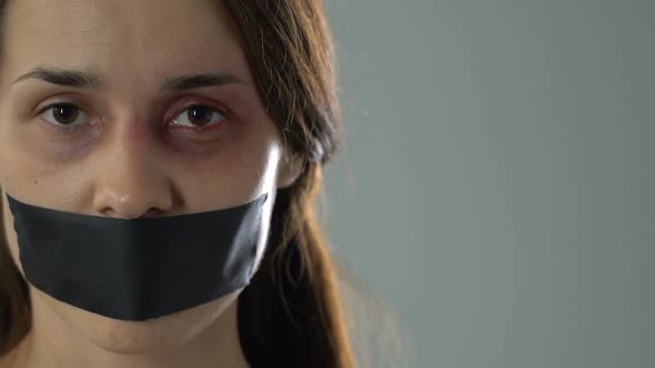 Sad Woman With Taped Mouth Showing Tied Hands, Helpless Kidnapping Victim