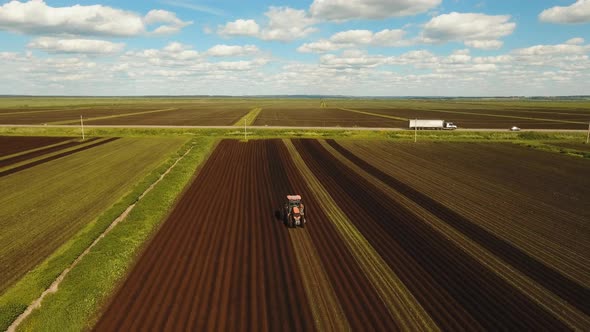 Tractor Cultivates the Land in the Field.