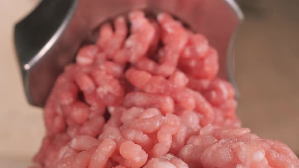 Filling Comes Out Through a Meat Grinder Sieve. Meat Grinder Close Up. Pile of Chopped Meat. Mincer