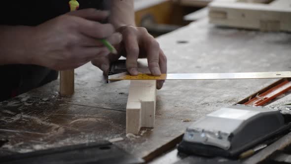 The Carpenter Marks the Wooden Workpiece with a Ruler and Pencil.