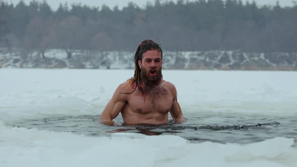 Naked Man Splashing Water in Ice Hole
