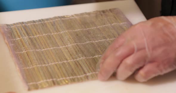 Putting fresh seaweed and rice for a delicious sushi roll - close up