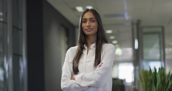 Video of happy biracial woman looking at camera in office