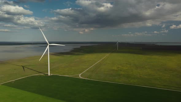 Aerial View of Wind Turbines and Agriculture Field Near the Sea at Sunset