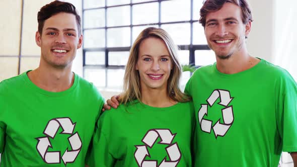 Volunteers wearing green ecologic t-shirt showing thumbs up