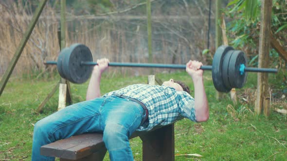 Backyard Young man bench pressing weights home gym