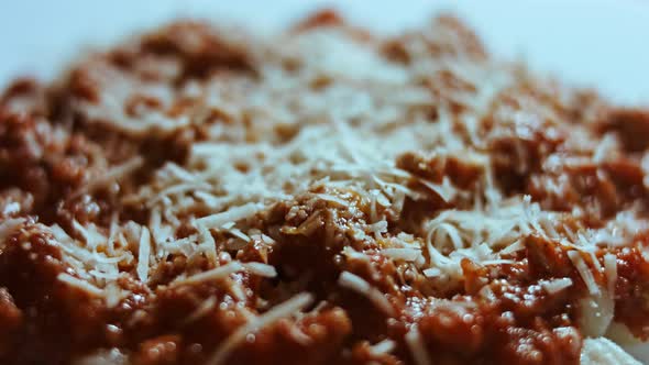 Gnocci with Tomato Sauce Being Sprinkled with Parmesan