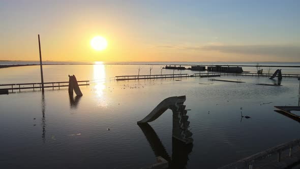 Aftermath of flood, ruins of popular pool and poolside slides at villa epecuen, glowing sun setting