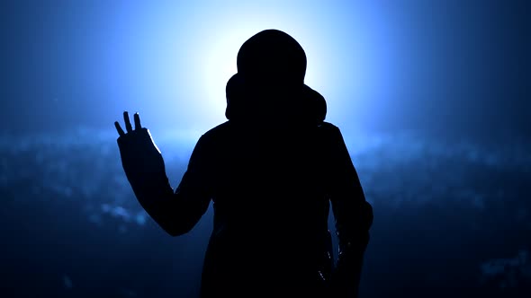 Silhouette of Alien Waving Hand  Hello on Blue Night Background