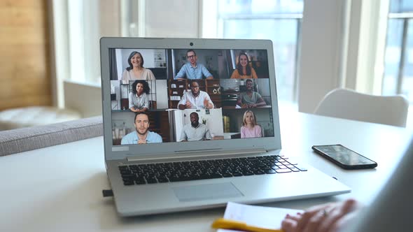 Young Woman Using Laptop for Video Meeting with Group of Diverse People