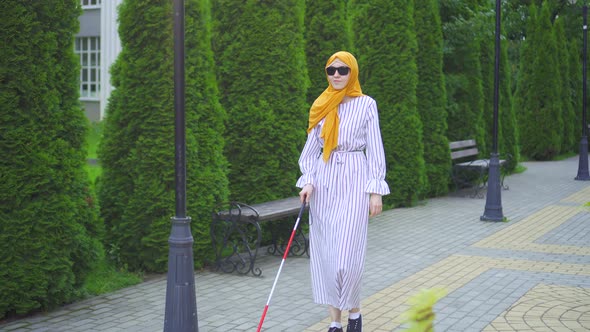 Young Attractive Muslim Woman Visually Impaired with a Walking Cane in the Park