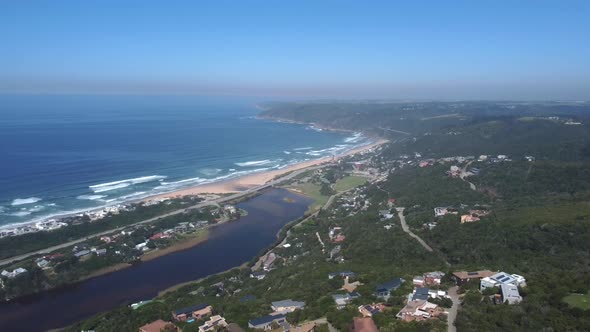 Drone shot of Wilderness hills in South Africa - drone is facing Wilderness beach, the bay and the o