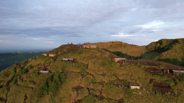 aerial circling local huts on a volcano rim during sunrise in Bali Indonesia