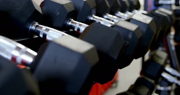 Dumbbells on a rack in fitness studio 4k