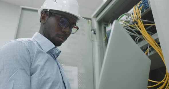 Man Using a Laptop While Working in a Server Room