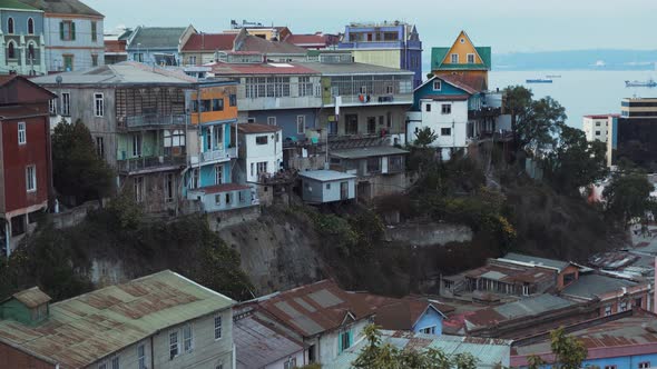 Jib up of picturesque colorful hillside houses in Cerro Alegre, sea in background on an overcast day