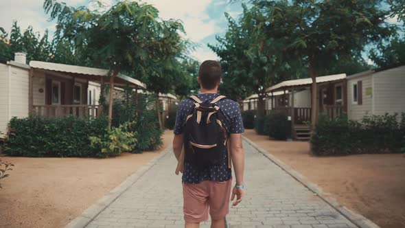 Male Tourist Walking Between Houses.