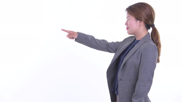 Profile View of Happy Young Asian Businesswoman Pointing Finger and Directing