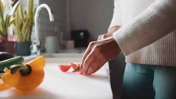 African pregnant woman cuts tomatoes