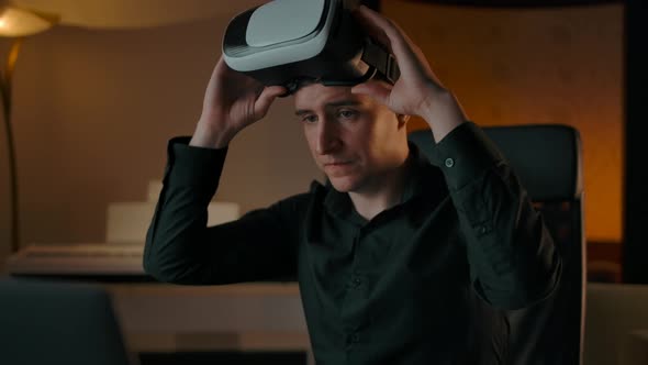 Engineer in Cozy Interior Working with Laptop in VR Helmet