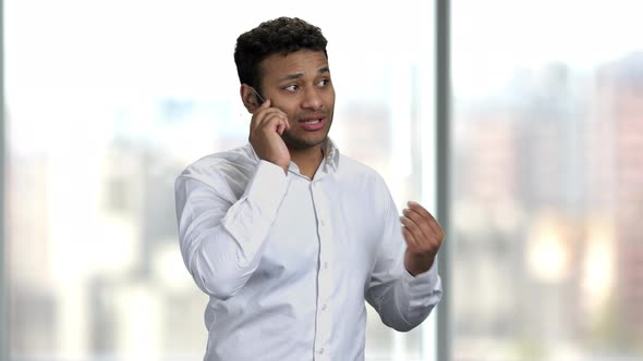 Dark-skinned Businessman Talking on Futuristic Phone