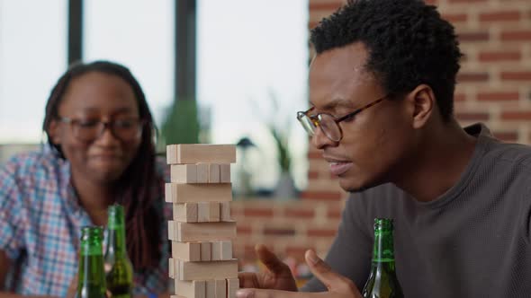 Group of Cheerful People Having Fun with Jenga Wooden Tower