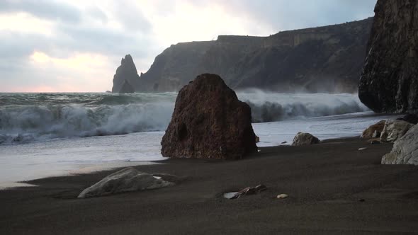 A Red Burning Sunset Over the Sea with Rocky Volcanic Basalt Cliff