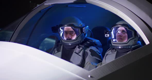 Male and Female Astronauts Navigating Spaceship