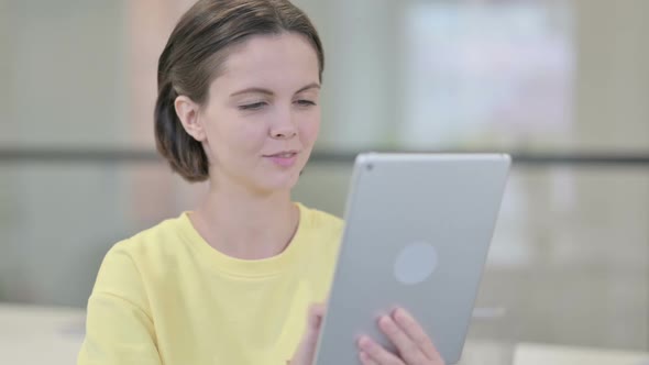 Young Woman Using Tablet Browsing Internet