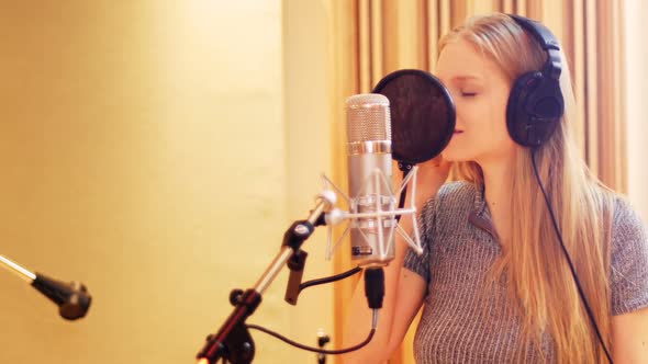 Woman singing in recording studio