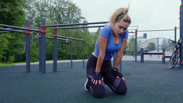 Fit Girl Sits on Her Knees After Hard Workout