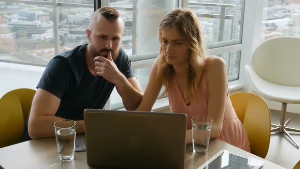 Couple using laptop in living room 4k