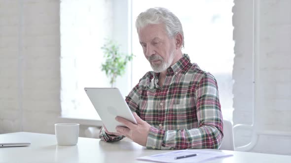 Hardworking Casual Old Man Using Tablet in Office