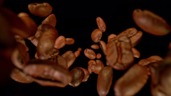 Super Slow Motion Detail Shot of Coffee Beans Falling Down on Black Background at 1000Fps