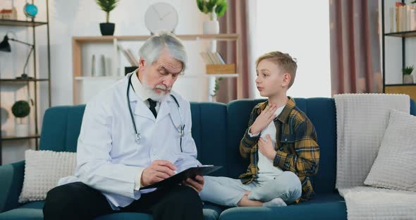 Doctor Talking with Teen Boy Patient, Filling Medical Card During Home Medical Appointment