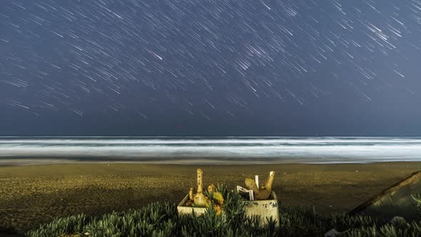 Star trails at night moving over beach at mediterranean sea, Italy