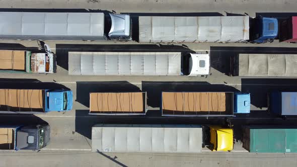 Top view on trucks standing in line at the terminal close up. Cargo transportation by tractors.