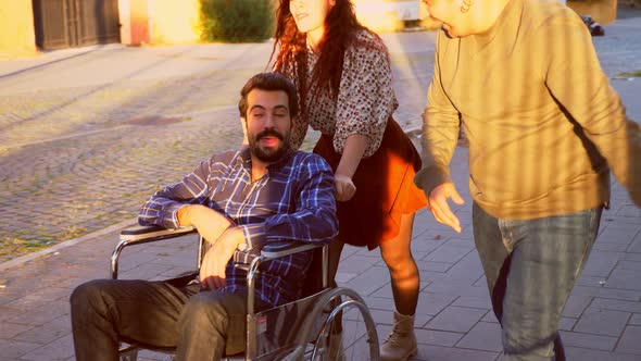 solidarity with a disabled person-friends assist and amuse a man with paraplegia