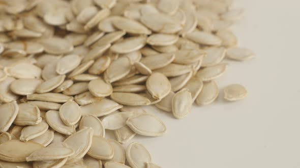 Close-up of organic pepitas slow tilt 4K 2160p 30fps UltraHD footage - Unpeeled pumpkin seed on pile