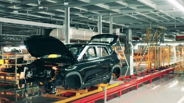 Black Car Body Moving on Assembly Line. Car Production Factory Interior.