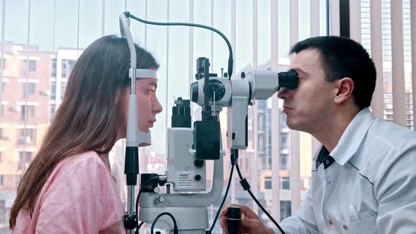 Doctor Checking Young Woman's Visual Acuity indoors