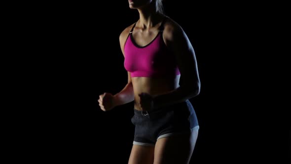 Woman in Sports Running on a Black Background. Silhouette. Slow Motion. Close Up