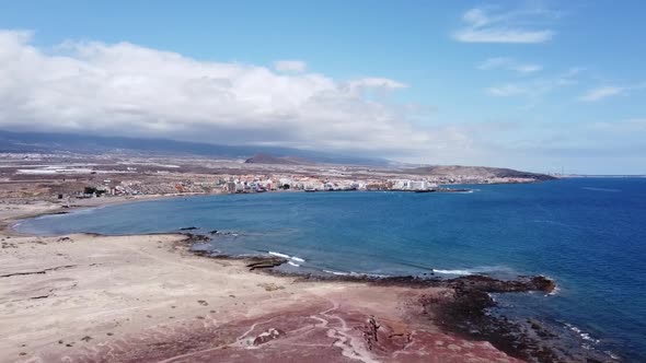 drone flight from montana roja to the bay of el medano (tenerife), sunny with clouds in the backgrou